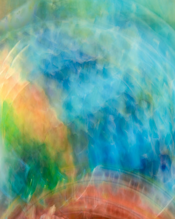 Concentric circles of vibrant blues, greens, red and peach exploding upwards