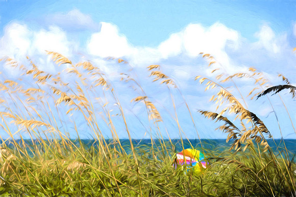 Artistic rendering of a colorful beach umbrella as seen through the tall dune grasses with blue ocean in background