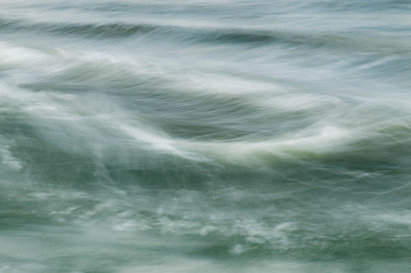 Deep green waters with white frothy tops in slow motion